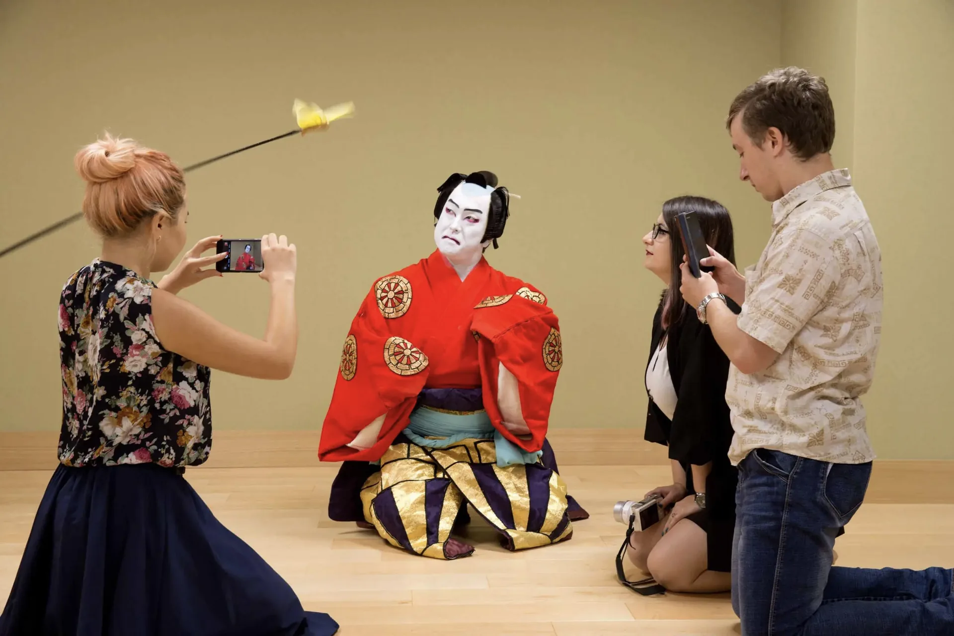 Guests photographing a kabuki-costumed performer during a private performance in a tatami room