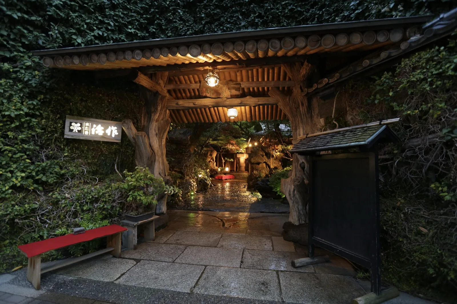The entrance gate of Tsukiji Jisaku at dusk, seen from the stone approach