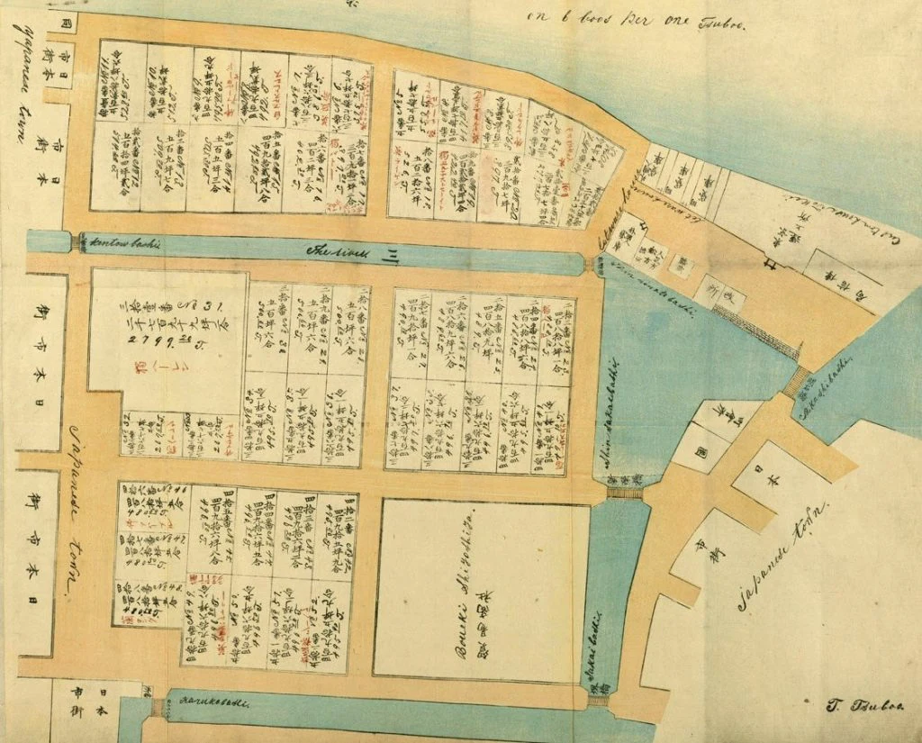 A hand-coloured survey map of the Tsukiji foreign settlement, its plots annotated in both Japanese and English